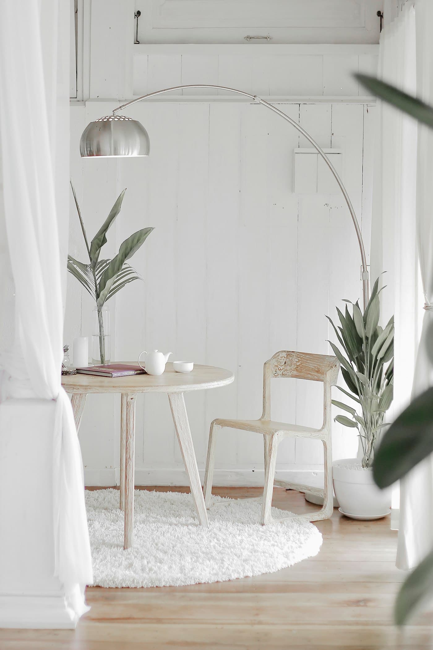 Airy white corner with a curved lounge chair and side table