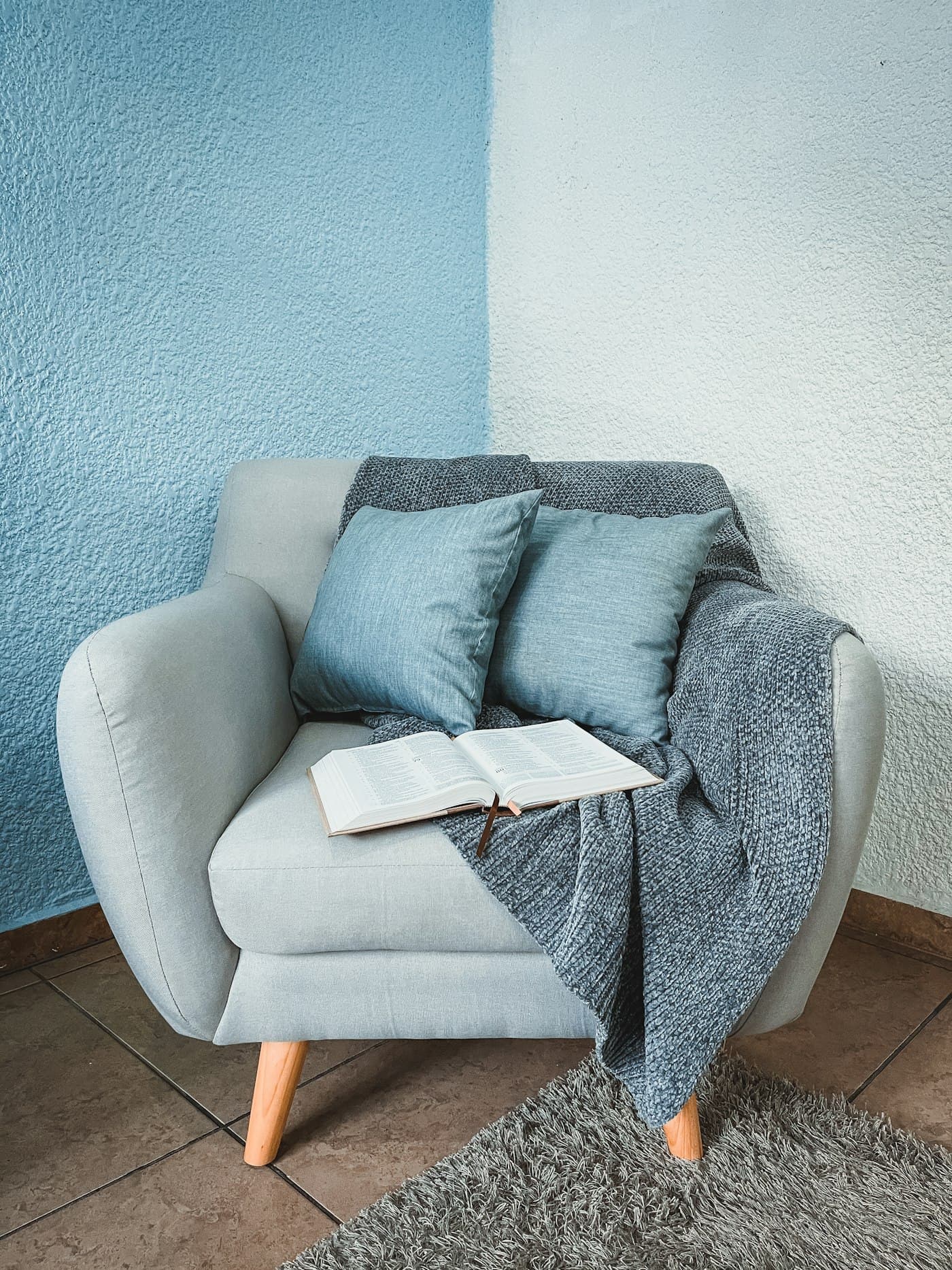 Reading corner with an armchair, throw and open book