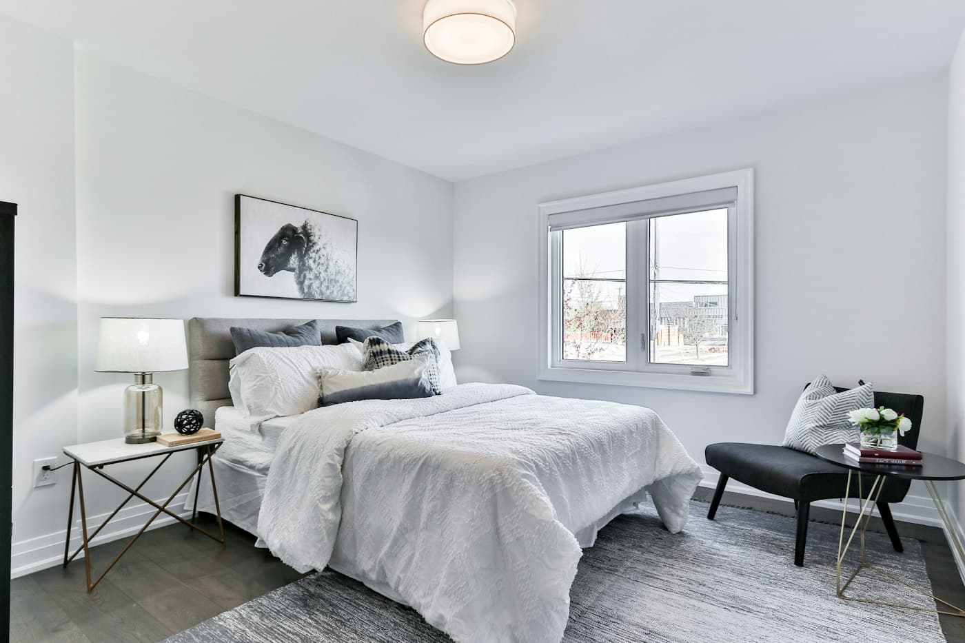 Calm grey bedroom with an accent chair by the window