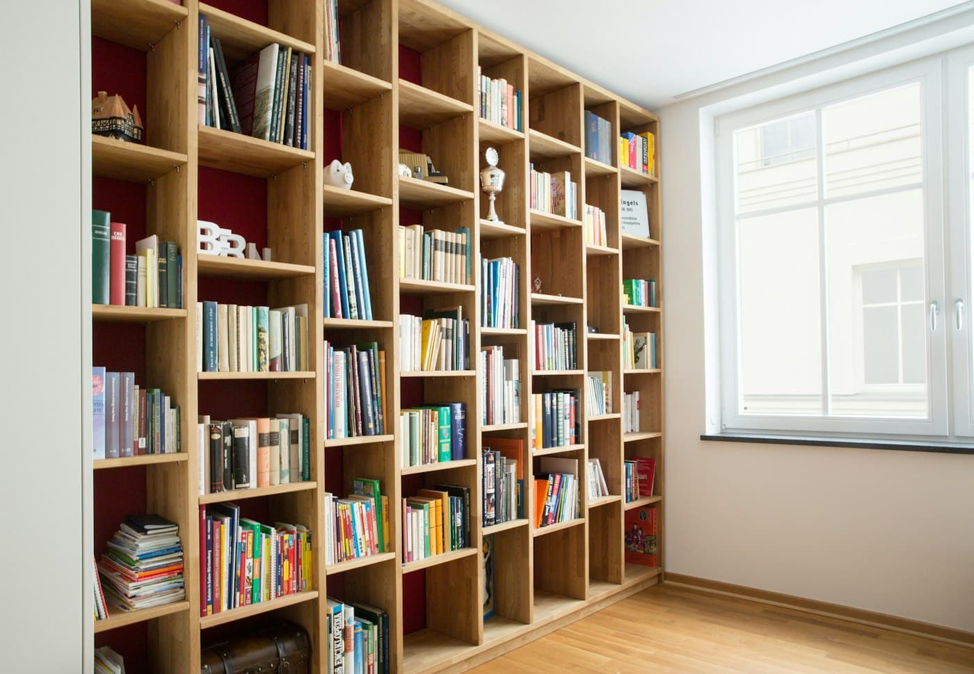 Floor-to-ceiling oak shelving filled with books